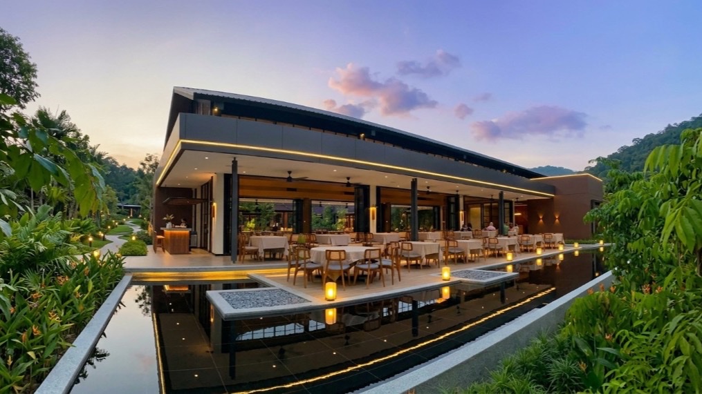 Orkid Ria pavilion dining room over a reflecting pool at sunset